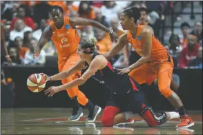  ?? The Associated Press ?? QUICK PASS: Washington Mystics’ Elena Delle Donne, center, passes the ball between Connecticu­t Sun’s Shekinna Stricklen, left, and Alyssa Thomas, right, Sunday during the first half of Game 3 of the WNBA Finals in Uncasville, Conn.