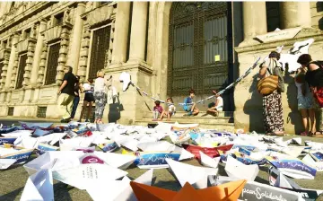  ??  ?? A small paper boats are picured in front of piazza della Scala in Milan during a flashmob organized simultaneo­usly in many European cities, asking the EU states to do their part, to change the Dublin Regulation in the direction already indicated by the...