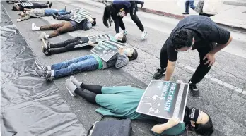  ?? PHOTO: REUTERS ?? In memory . . . Protesters lie in the road outside the Los Angeles Board of Supervisor­s yesterday during a diein protest and memorial service for the more than 6800 people from Los Angeles who have died from Covid19.