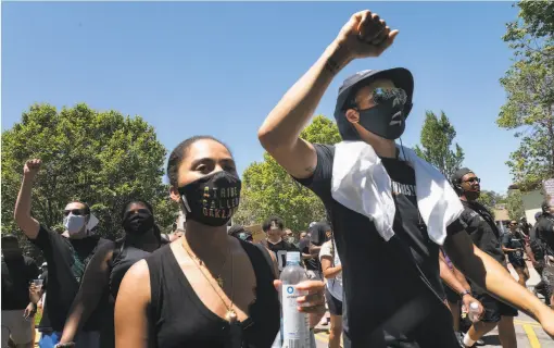  ?? Paul Kuroda / Special to The Chronicle ?? Stephen Curry and wife Ayesha march around Oakland’s Lake Merritt with other Warriors to protest the killing of George Floyd by police.