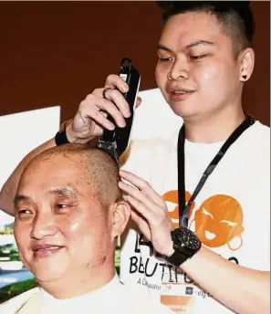  ??  ?? Getting prepared: Ng getting his head shaved at the Khind Starfish Foundation’s Bald is Beautiful 3.0 programme.