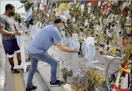  ?? A LINE OF WOODEN HEARTS Anna Moneymaker Getty Images ?? representi­ng those killed in the Champlain Towers South collapse in Surfside, Fla., kept growing this month as remains were found and identified. The death toll stands at 97 as search crews leave, with one woman still not accounted for.