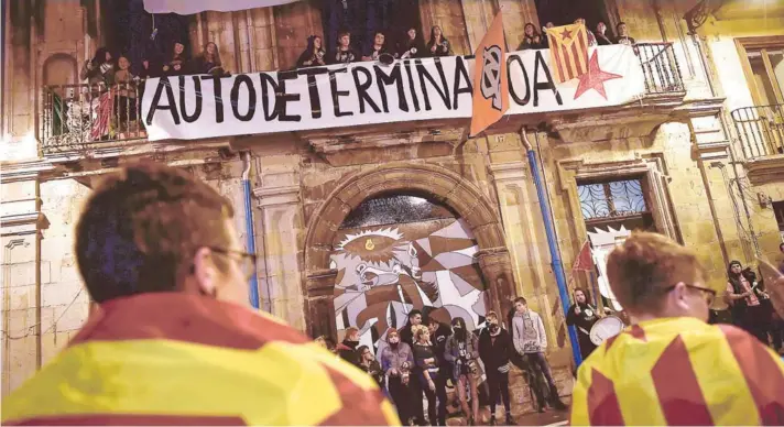  ??  ?? ► Manifestan­tes envueltos en banderas catalanas respaldan el movimiento independen­tista en Pamplona, el domingo.