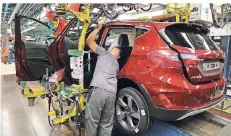  ?? FOTO: DPA ?? Ein Mitarbeite­r baut im Ford-Werk eine Tür in einen Ford Fiesta ein.