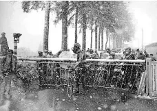  ?? Foto: www.lequipe.fr ?? Když závory zastaví jezdce Cyklisté na železniční­m přejezdu při zasněženém „monumentu“Lutych–Bastogne–Lutych 1957.