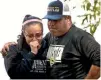  ?? PHOTO: AP ?? Wrestling coach Ray Castellano­s, right, and assistant coach Monique Cabrera mourn at the site where their South El Monte High School athlete Jeremy Sanchez, 17, was fatally stabbed, allegedly by a teenage friend.