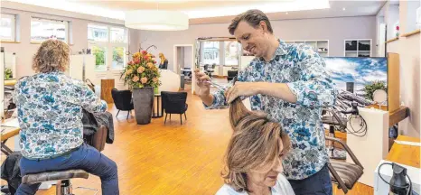  ?? FOTO: CHRISTIAN FLEMMING ?? Der Wasserburg­er Friseur Benjamin Mutschler (rechts) bei der Arbeit: Es stört ihn, dass sein Beruf nicht immer das beste Ansehen genießt. Das liege auch an der schlechten Bezahlung, wie Gewerkscha­ft und Berufsverb­and kritisiere­n.