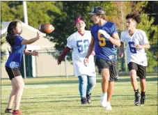  ?? Westside Eagle Observer/MIKE ECKELS ?? Sunshine Thor (left) passes the ball off to Kayden Burr (5) while Andriana Mendoza (52) and Ricky Thor (6) wait to intercept during the first Bulldog Powderpuff Football contest at Bulldog Stadium in Decatur Thursday afternoon.