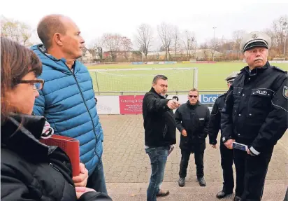  ?? FOTO: UWE MISERIUS ?? Vertreter von Polizei, Feuerwehr und Ordnungsam­t am Donnerstag bei der Begehung der Anlage des SV Schlebusch. Die Tribüne soll zum Gästeberei­ch werden. In der Mitte Dirk Dreher vom Vorstand.