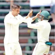  ?? (AFP) ?? South African bowler Duanne Olivier (left) celebrates with his teammate after taking a wicket against Pakistan in Johannesbu­rg on Saturday