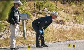  ?? JAY JANNER / AMERICAN-STATESMAN ?? Texas Rangers investigat­e on Spoke Hollow Road behind Jean’s Antique Mall in Wimberley on Friday after the officer-involved shooting.