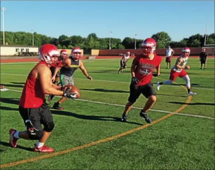  ?? JOHN KAMPF — THE NEWS-HERALD ?? Perry senior Tyler Horvath is chased by teammates during a pursuit drill on the first day of football practice July 31 at Perry’s Alumni Stadium.