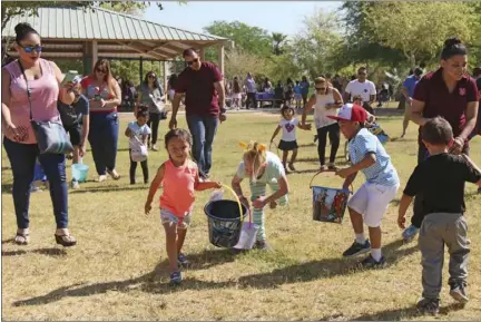  ?? WILLIAM ROLLER PHOTO ?? FROM RIGHT: Vanessa Young and son Ayden (back turned) set out for the third annual Easter Egg Hunt organized by Cody’s Closet founder Heather White, at Sunbeam Lake in Seeley on Saturday.