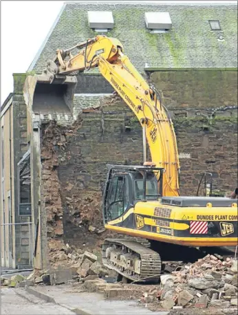  ??  ?? A bulldozer gets to work on pulling down the building that held so many memories.