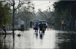  ?? JOHN LOCHER — THE ASSOCIATED PRESS ?? People walk up a street in Jean Lafitte, La., flooded in the aftermath of Hurricane Ida on Wednesday.