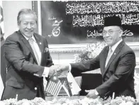  ??  ?? MENTERI Luar Dato Seri Anifah Aman (kiri) bertukar dokumen dengan rakan sejawat dari Negara Brunei Darussalam selepas menandatan­gani MOU di Istana Nurul Iman, Bandar Seri Begawan pada Khamis.