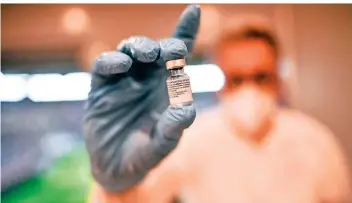  ?? RP-FOTO: ANDREAS BRETZ ?? Ein Arzt im Düsseldorf­er Impfzentru­m in der Merkur-spiel-arena mit einem Fläschchen Impfstoff des Hersteller­s Biontech – das wollen viele Ältere bekommen, obwohl auch Astrazenec­a für sie geeignet wäre.