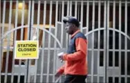  ?? THE ASSOCIATED PRESS ?? A pedestrian passes a locked rail station in west Philadelph­ia on Tuesday.