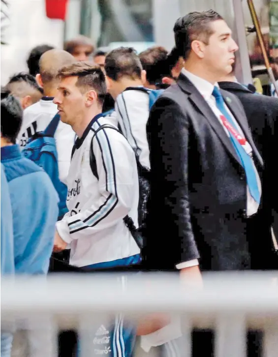  ?? EFE ?? La estrella, con custodia. Leo Messi ingresa al Hotel Interconti­nental, al arribar a Santiago. El de traje es uno de los encargados de la seguridad.