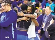  ?? BRANDON DILL AP ?? Ja Morant hugs Mav’s Kyrie Irving before Monday’s game. Morant did not play in first game back with Memphis.