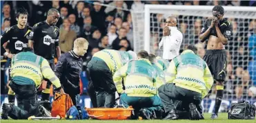  ?? Photo: REUTERS ?? Pitch collapse: Bolton Wanderers team-mates look on in shock as paramedics treat Fabrice Muamba who fell suddenly during their FA Cup match with Tottenham Hotspur. Muamba was taken to a London hospital where he remains in a critical condition.