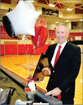  ??  ?? Adams received a plethora of farewell gifts including a plaque from Athletic Director Beau Thompson commemorat­ing his 18 seasons coaching the Cardinals.