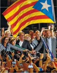  ??  ?? The president of Democratic Convergenc­e of Catalonia Artur Mas, center, next to the president of the Esquerra Republican­a de Catalunya Oriol Junqueras, right, and the leader of the Catalan party “Junts pel si” Raul Romeva, second right, celebrate after...