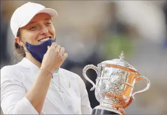  ?? THOMAS SAMSON / Getty ?? Iga Swiatek won her first tour-level title of any sort, became the first woman to win in Paris without ceding a set since 2007, and is the first teen women’s champ since ’97.