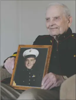  ?? BEA AHBECK/NEWS-SENTINEL ?? World War II veteran Darrell “Bob” Eugene Potter, wearing his original uniform, holds an image of himself as a Marine Corps sergeant back in 1944 at age 17 as he sits in his Lodi home Tuesday. Potter enlisted in the Marine Corps at age 16 to fight in the war.