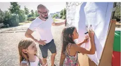  ?? RP-FOTO: HANS-JÜRGEN BAUER ?? Fay (l.) und Ava malen ihre Wünsche für die Freizeitei­nrichtung auf, Jonas Höhn begutachte­t den Vorgang.