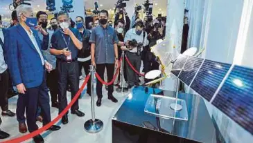  ?? ?? ISMAIL Sabri melihat replika satelit Measat-3d ketika melawat sekitar kawasan pameran.