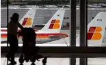  ?? ?? Des avions d'Iberia sont vus dans une zone de stationnem­ent alors qu'une passagère porte ses bagages.