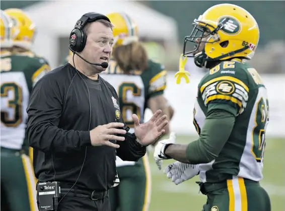  ?? Jason Franson/The Canadian Press ?? Edmonton Eskimos rookie head coach Chris Jones talks with AJ Guyton during CFL action against the B.C. Lions. So far, so good for the new, less theatrical and vociferous Jones as the Esks have won their first two games and look like one of the teams to...