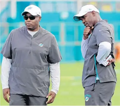  ?? AMY BETH BENNETT/SUN SENTINEL ?? Dolphins general manager Chris Grier, left, and coach Brian Flores, seen here watching a June practice, do not have a great deal of talent with which to work this season. As a result, a winning record has to be considered a long shot.