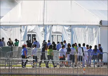  ?? Wilfredo Lee Associated Press ?? CHILDREN ENTER a tent in Homestead, Fla. A pediatrici­an who visited a warehouse holding migrant children reported malnutriti­on as well as sanitation “tantamount to intentiona­lly causing the spread of disease.”