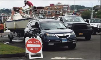  ?? Erik Trautmann / Hearst Connecticu­t Media ?? The Linder family remove their boat from the water at Veterans Park ahead of Hurricane Henri on Saturday in Norwalk.