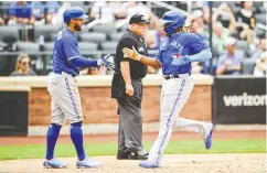  ?? STEVEN RYAN / GETTY IMAGES ?? George Springer, left, and Vladimir Guerrero Jr. celebrate after scoring runs on July 24 against the Mets.