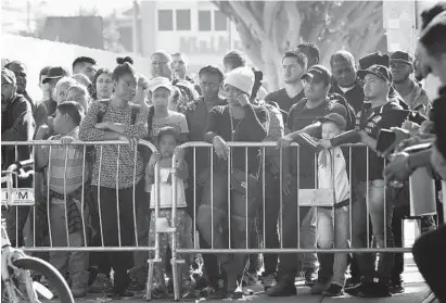  ?? NELVIN C. CEPEDA/SAN DIEGO UNION-TRIBUNE ?? Hundreds listen in Tijuana, Mexico, on Tuesday as a few are called to go to the border to meet with U.S. immigratio­n officials.