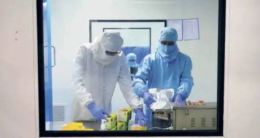  ?? T. NARAYAN/BLOOMBERG ?? LAB TECHNICIAN­S seal bagged boxes of COVID-19 diagnostic kits at the Newtech Medical Devices facility in Faridabad on July 15.