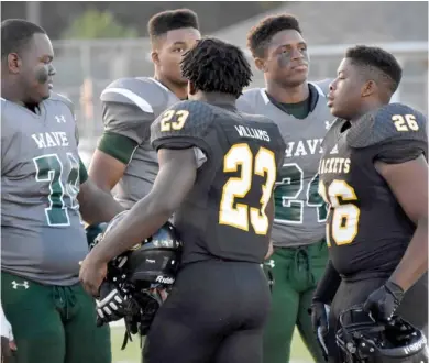  ?? (Photo by Jason Cleveland, SDN) ?? Starkville High School players Jacob Williams (23) and KJ Lawrence (26) greet West Point players prior to last year’s meeting between the two rivals.