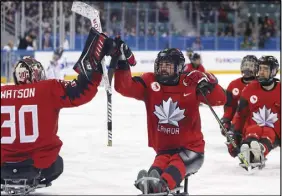  ?? AP PHOTO ?? Canada’s Billy Bridges, centre, celebrates a goal with goalkeeper Corbin Watson during Thursday’s semifinal game against South Korea.