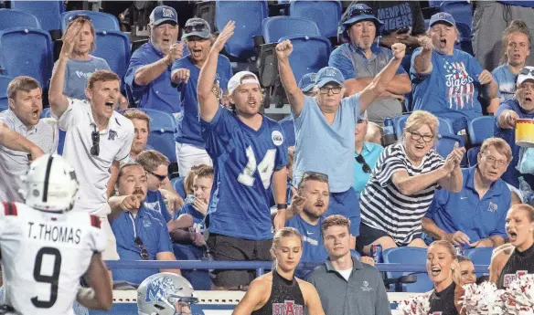  ?? CHRISTINE TANNOUS / THE COMMERCIAL APPEAL ?? Memphis Tigers fans celebrate during the first half of Memphis’ 44-32 victory against Arkansas State on Saturday.