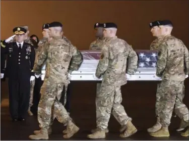  ?? AP PHOTO/STEVE RUARK ?? Army Chief of Staff Gen. Mark A. Milley, left, salutes as an Army carry team moves a transfer case containing the remains of Maj. Brent R. Taylor at Dover Air Force Base, Del., on Tuesday. According to the Department of Defense, Taylor, 39, of Ogden, Utah, died Saturday in Kabul province, Afghanista­n, of wounds sustained from small arms fire.