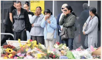  ?? MICK TSIKAS/AAP/DPA ?? PEOPLE at a makeshift memorial at the Botanical Gardens commemorat­e the victims of Friday’s Christchur­ch horror mosque attacks. |