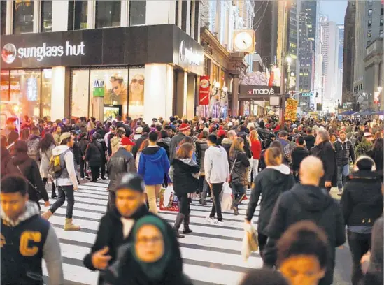  ?? Eduardo Munoz Alvarez Getty Images ?? BLACK FRIDAY shoppers walk in New York City last year. The National Retail Federation expects holiday retail sales to reach as much as $682 billion this year.