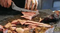  ?? Photos by Kin Man Hui / Staff photograph­er ?? Bandit BBQ owner-pitmaster Brandon Peterson cuts into tritips. Because the grain of the meat can change, slicing is tricky.