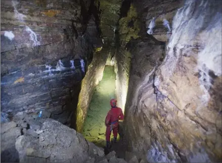  ?? GRAHAM HUGHES, THE CANADIAN PRESS ?? Cave explorer Daniel Caron looks at the walls of a cave located under a city park in Montreal.