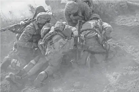  ?? MUNIR UZ ZAMAN/AFP VIA GETTY IMAGES ?? U.S. Army soldiers protect a comrade wounded by an improvised bomb in Afghanista­n’s Logar Province in 2012.