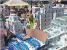  ?? PHOTOS BY JAE C. HONG/AP ?? A volunteer works at a food and supply distributi­on center Wednesday in Lahaina, Hawaii