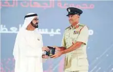  ??  ?? Shaikh Mohammad awarding Lieutenant-Colonel Khabeer ■ Mohammad Eisa Al Adab of Dubai Police.